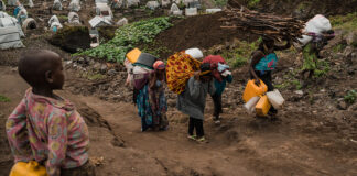 Displaced community members in Goma begin their journey back to home villages carrying their personal belongings.