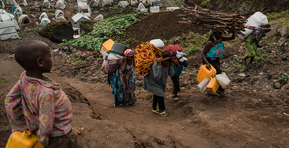 Displaced community members in Goma begin their journey back to home villages carrying their personal belongings.