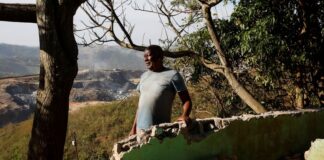Albert Mthembu next to a demolished house in Magog, South Africa.