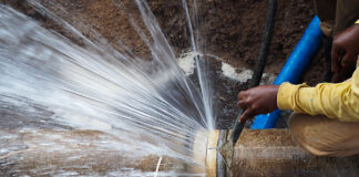 Burst water pipe leaking water due to aging municipal infrastructure in South Africa